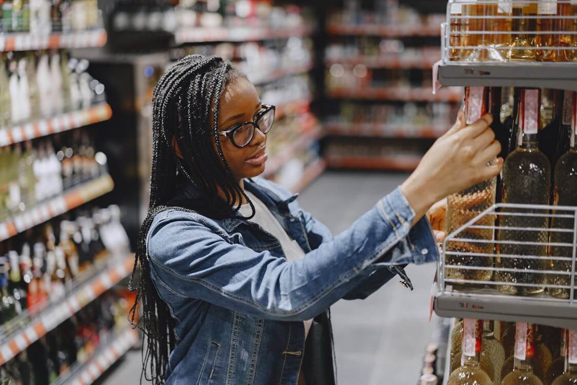 woman looking at wine bottles in grocery store