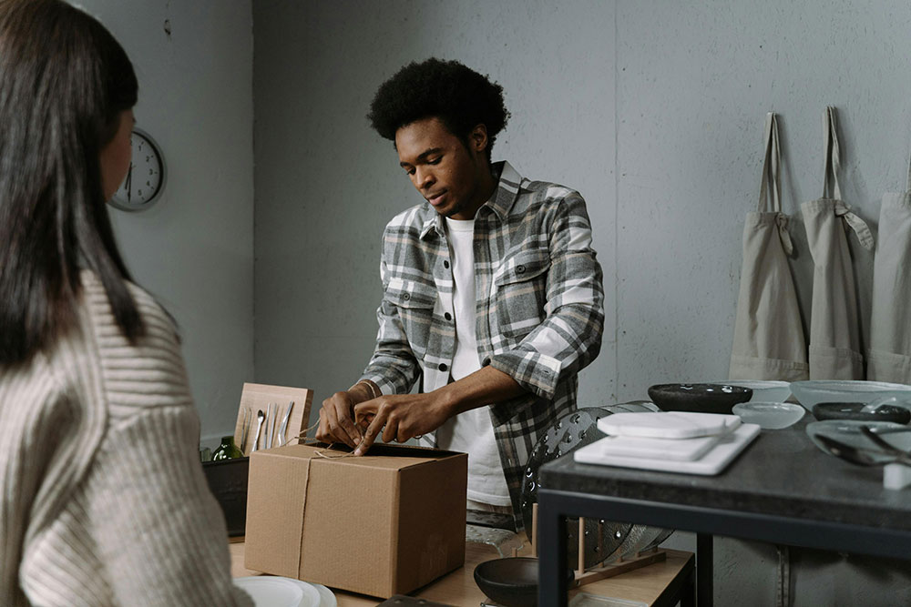 A clerk packaging a customer’s purchase into a box