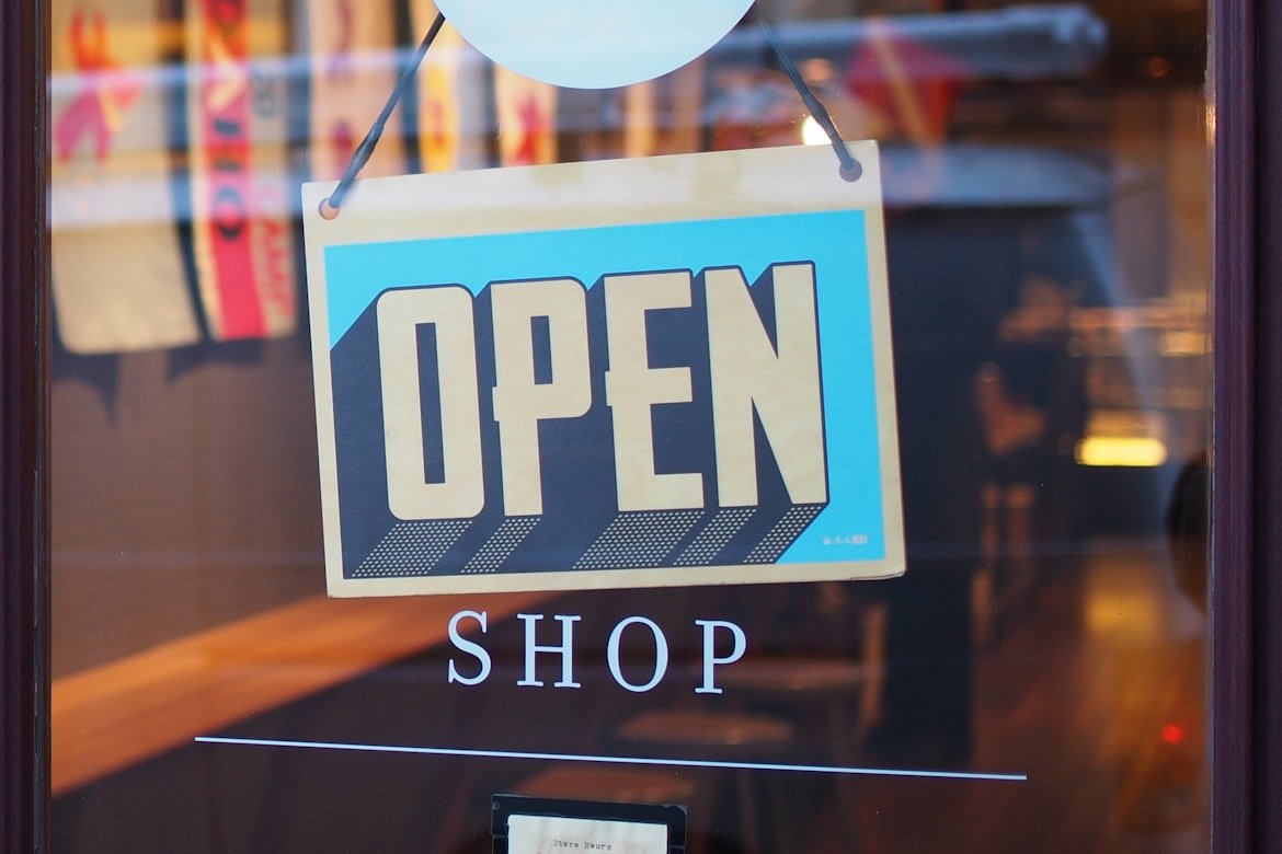 A blue open sign on a store door