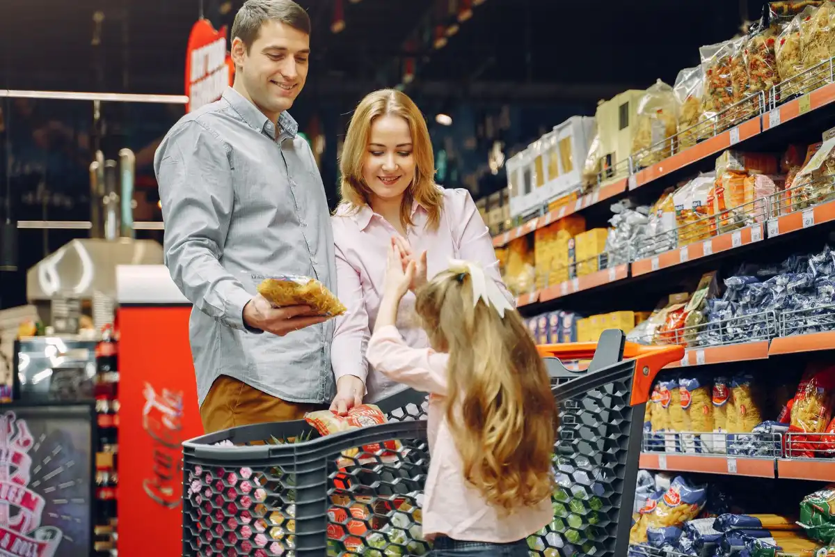 Family shopping in a grocery store with products stacked cleanly on shelves